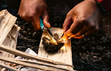 Someone using a Leatherman Signal fire starter to light a camping stove.